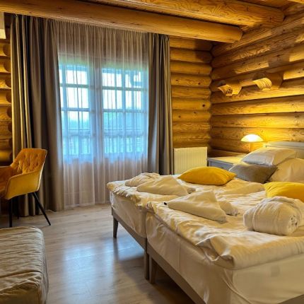A Szent Orbán Erdei Wellness Hotel farönk épületi szobája két külön ággyal, ahol autentikus farönk falak és erkély várja a vendégeket